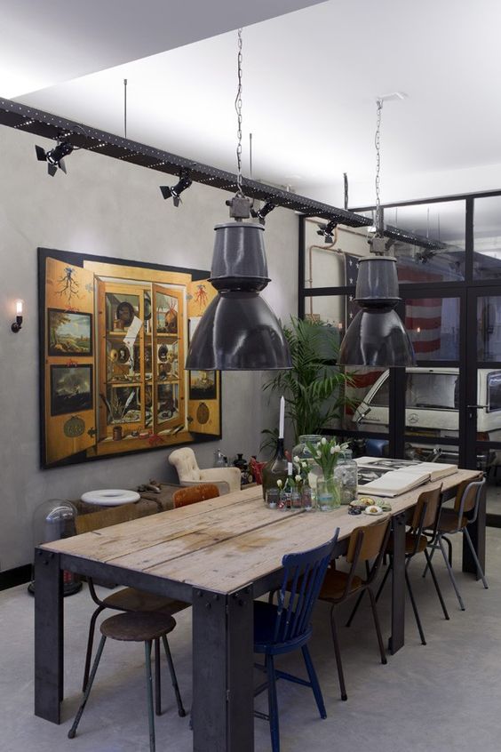 Industrial lamps hang over a custom table in a home built inside a restored commercial building dating from the 1950s in Amsterdam, Jan. 15, 2014. The unconventional living space hidden behind a steel roll-down door belongs to James van der Velden, an architect and interior designer who planned much of the decor as homage to the building's industrial past. (Andreas Meichsner/The New York Times)